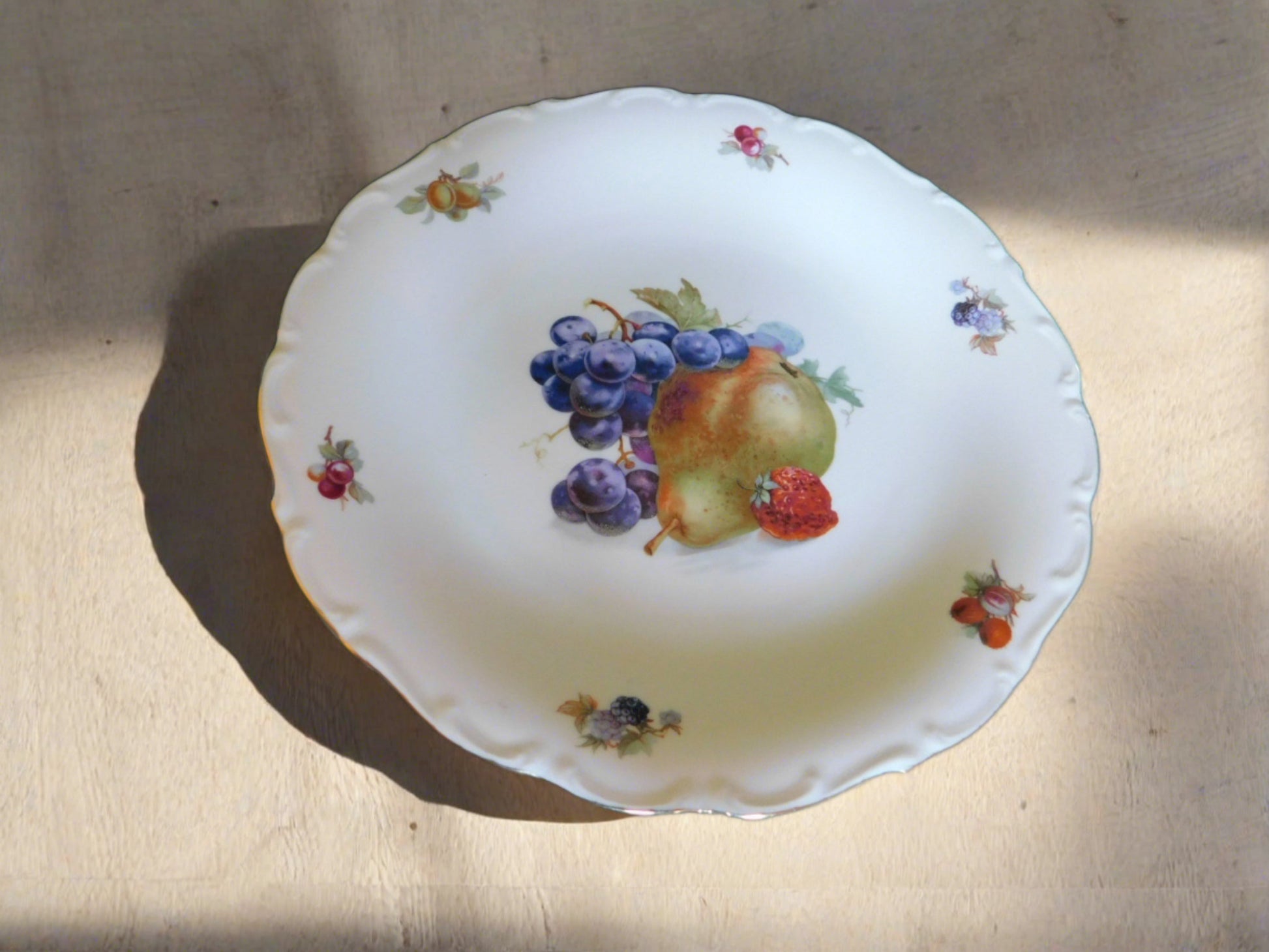 Chop plate or large platter in a fruit pattern featuring grapes and a pear, scalloped embossed edge with gold accenting, numbered 2 on reverse